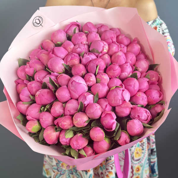 Large bouquet of bright pink peony buds wrapped in pale pink paper