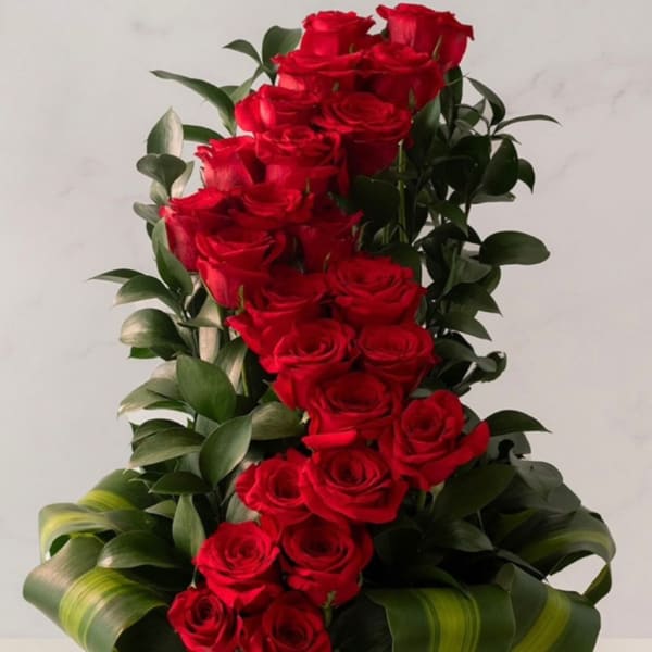 Tall arrangement of red roses in a black hat box