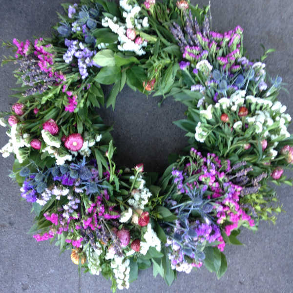 Circular floral wreath with purple, pink, and white blooms