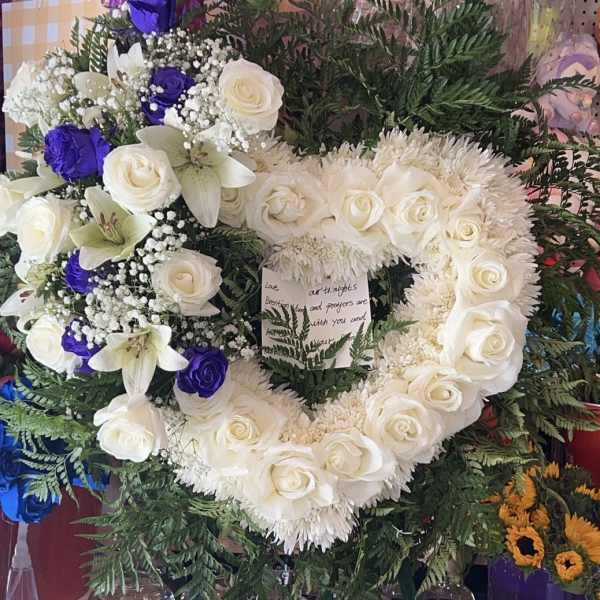 Heart-shaped floral wreath with white roses, lilies, and purple roses