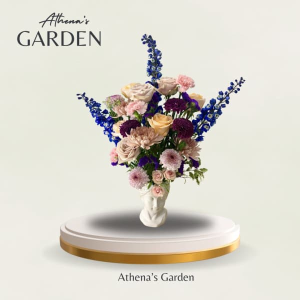 Tall mixed bouquet in a white sculpted vase with blue and pink flowers