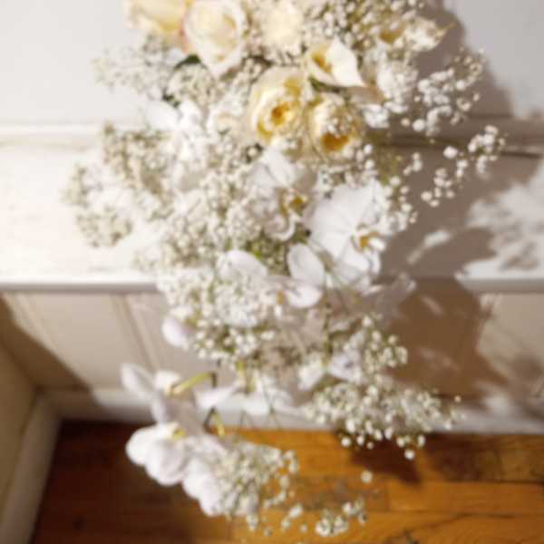 White rose bouquet with baby's breath cascading downward