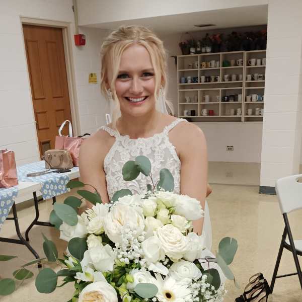 Bride holding a white bouquet with eucalyptus and roses