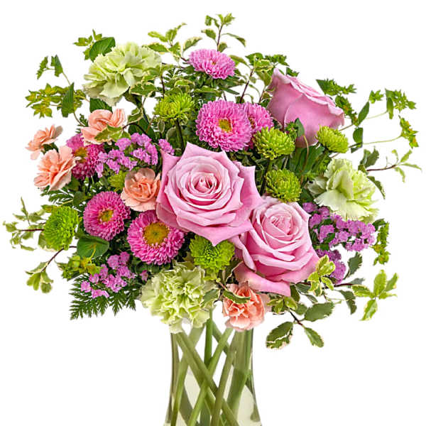 Pink roses and mixed flowers in a clear glass vase