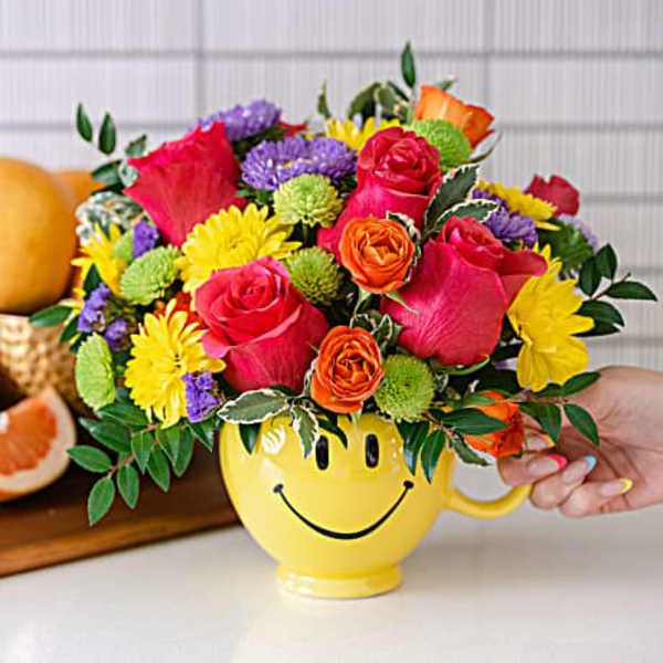 Colorful mixed bouquet in a yellow smiley-face mug