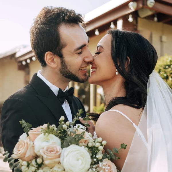 Bride and groom holding a pale rose bouquet