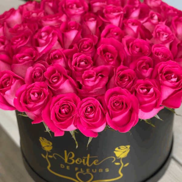 Hot pink roses arranged in a black round box