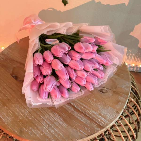 Bouquet of pink tulips wrapped in pale pink paper
