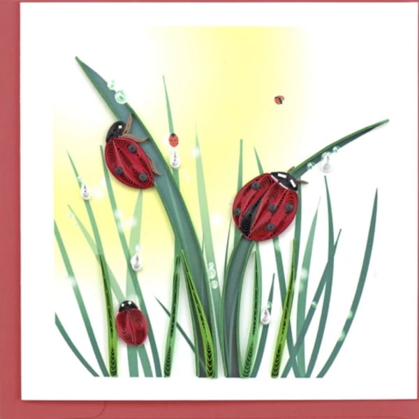 Paper art of red ladybugs on tall green grass