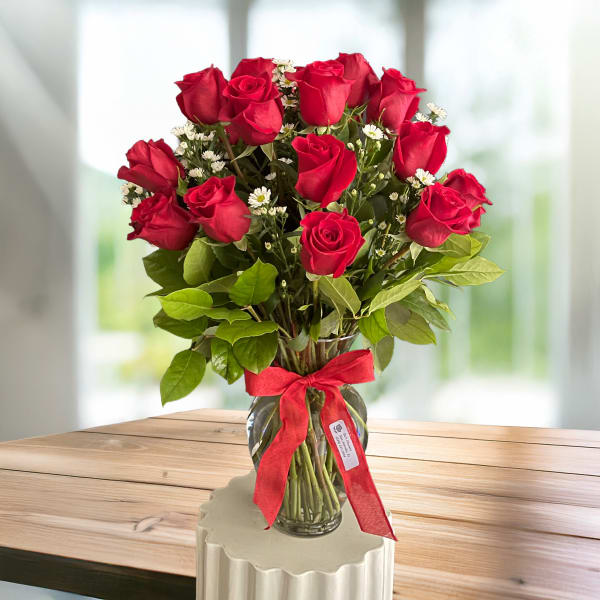 Red roses in a glass vase with a red ribbon