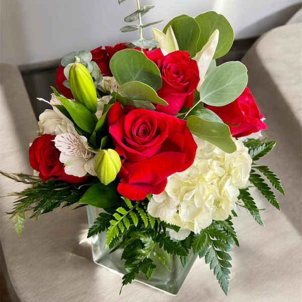 Red roses and white hydrangea in a square glass vase