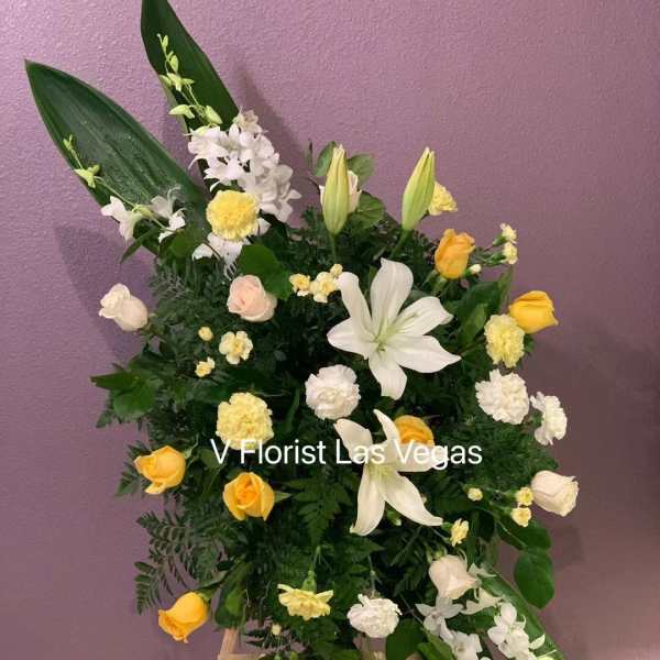 Standing floral spray with white lilies, yellow roses, and white orchids