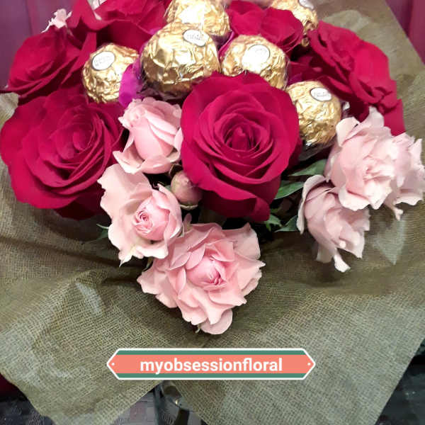 Bouquet of red and pink roses with gold-wrapped chocolates