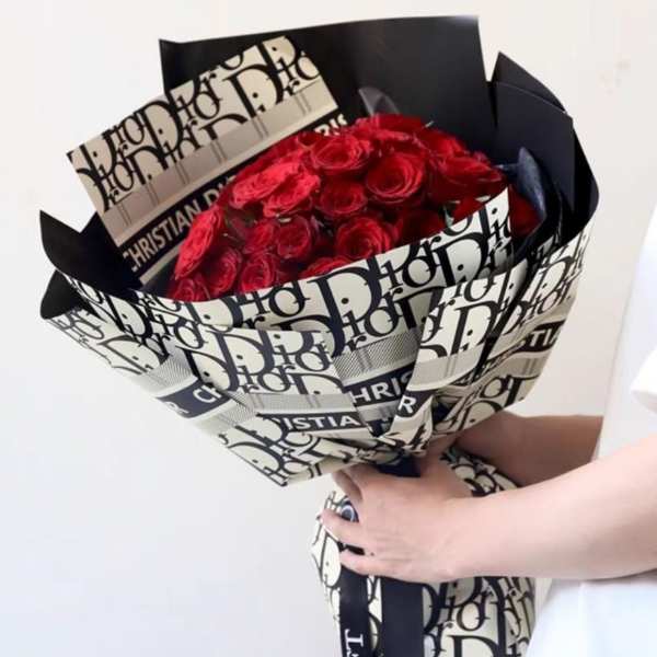 Bouquet of red roses wrapped in black-and-white Dior paper
