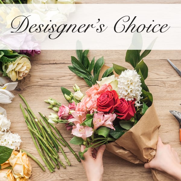 Handheld bouquet of mixed roses and pink flowers wrapped in brown paper
