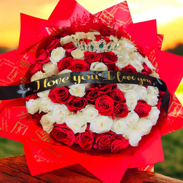 Bouquet of red and white roses with a jeweled crown and love ribbon