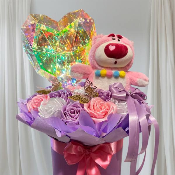 Pink teddy bear in a purple gift box with satin roses and a holographic heart