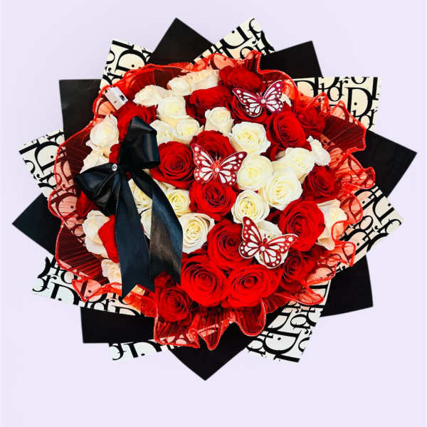 Red and white rose bouquet with a black ribbon and butterfly accents