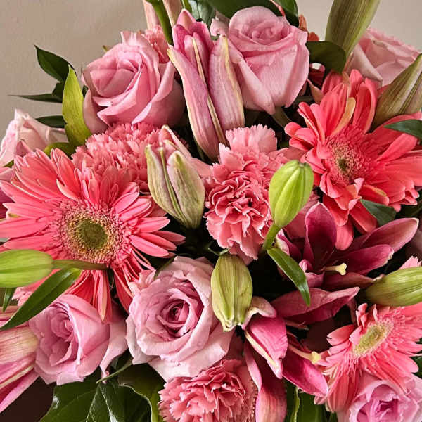Pink roses, gerbera daisies, lilies, and carnations in a bouquet