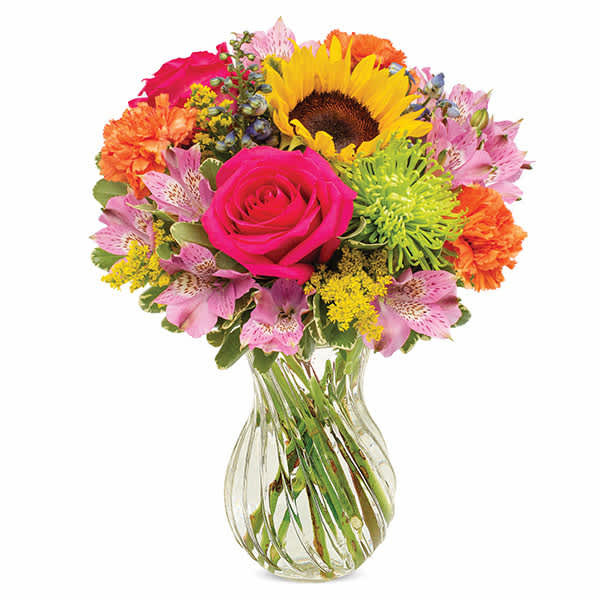 Mixed bouquet with a pink rose, sunflower, and colorful blooms in a clear glass vase
