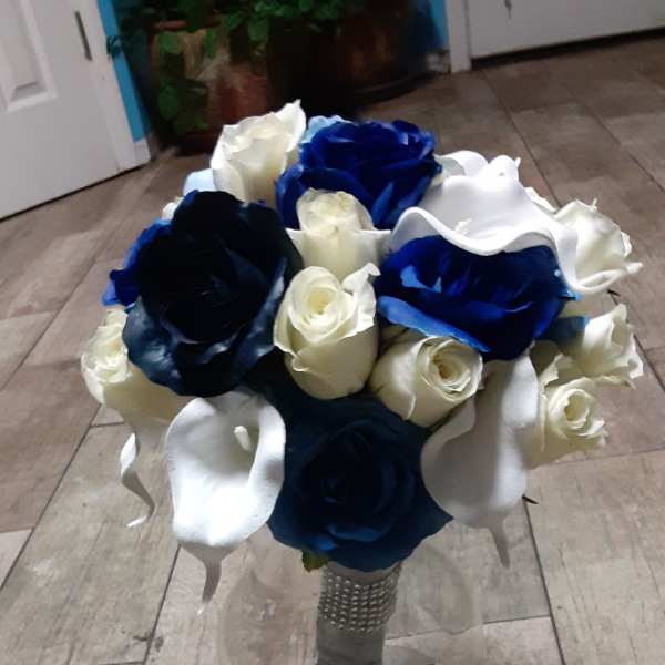 Bouquet of blue, white, and cream roses in a glass vase