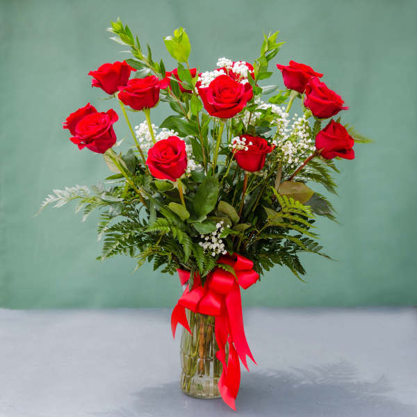 Red roses in a glass vase with a red ribbon