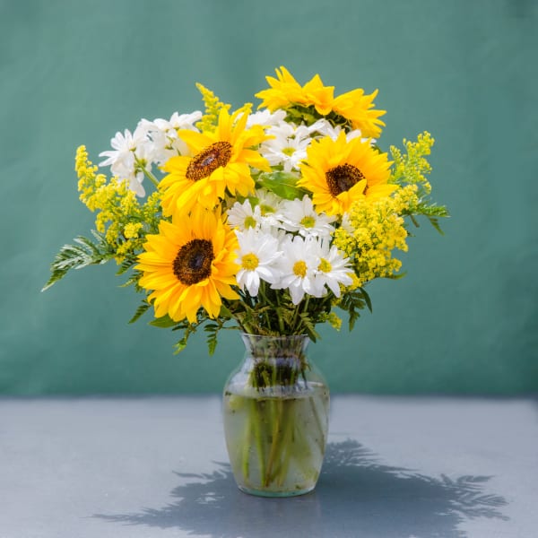 Sunflowers and white daisies in a clear glass vase
