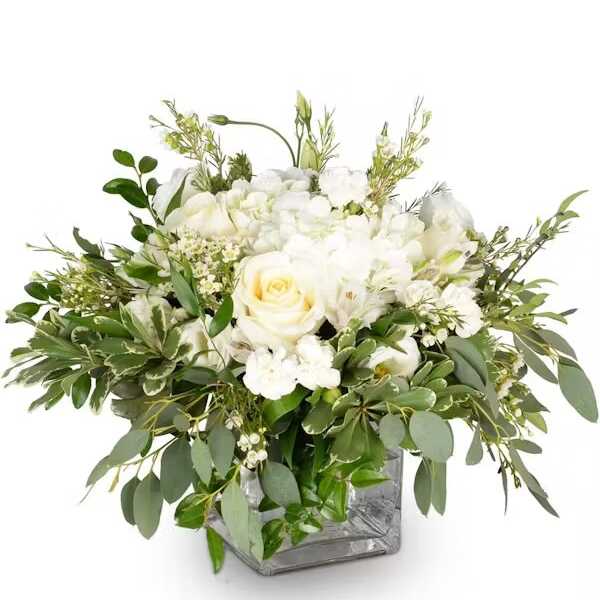 White rose arrangement in a square glass vase with mixed greenery