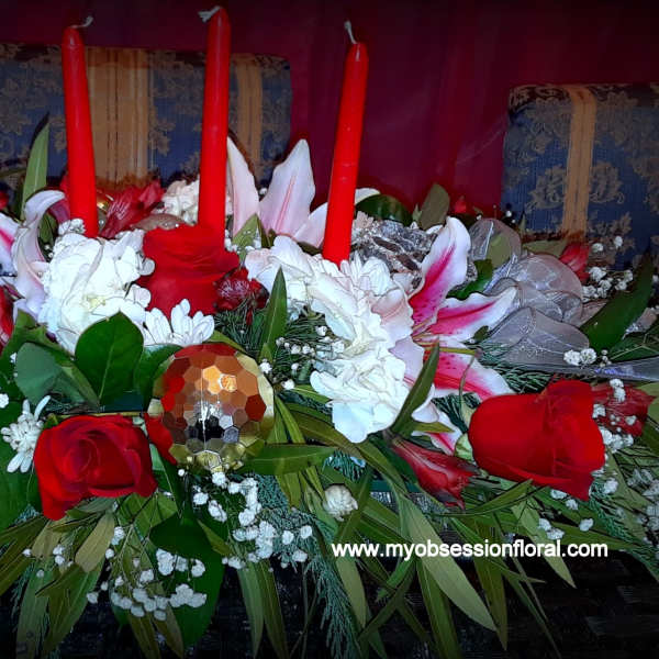 Red and white floral centerpiece with tall red candles
