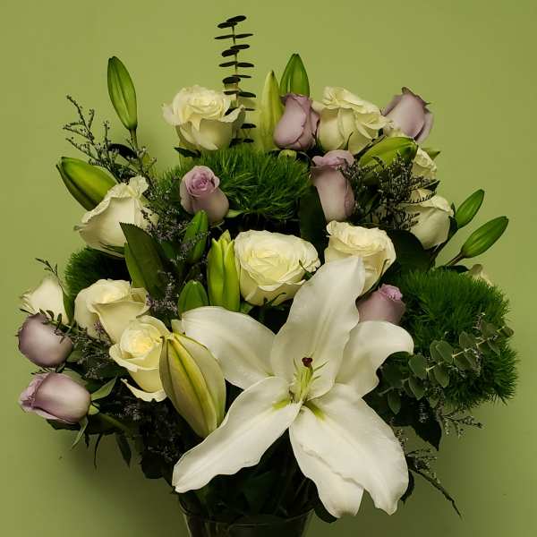 White lilies and pale roses in a glass vase