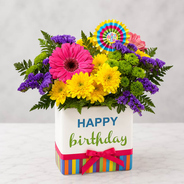 Bright mixed flower arrangement in a birthday gift box with a ribbon
