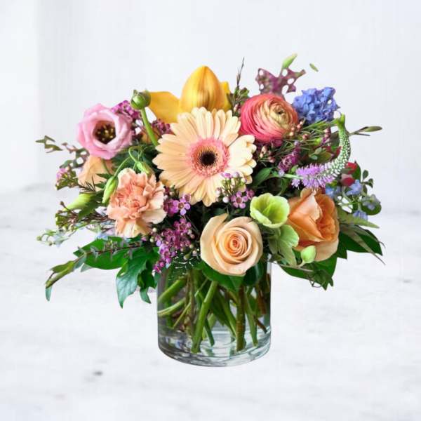 Mixed bouquet of pastel flowers in a clear glass vase