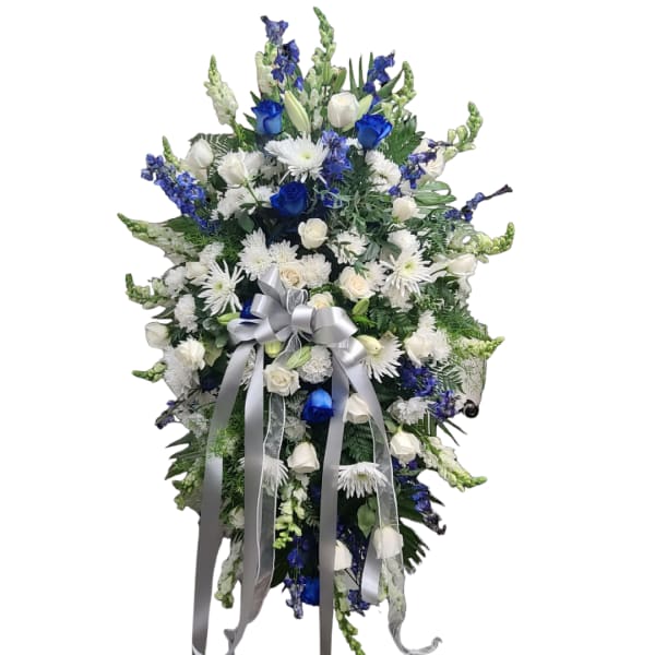 Tall blue and white floral standing spray with a silver ribbon bow