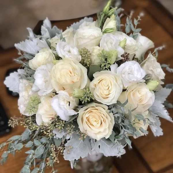 Bouquet of white roses and pale blooms with silvery foliage