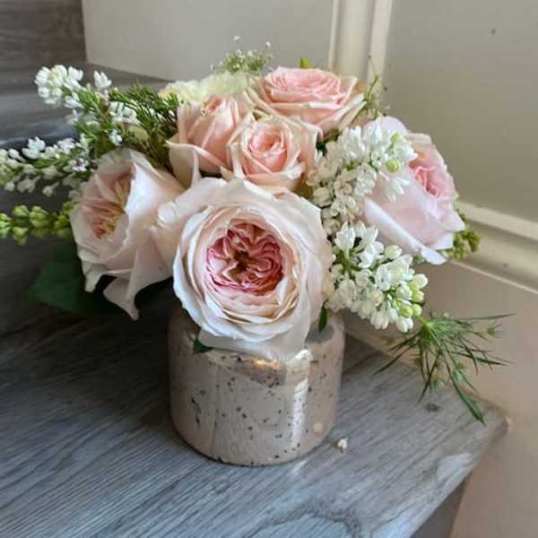 Pink roses arranged in a small ceramic vase