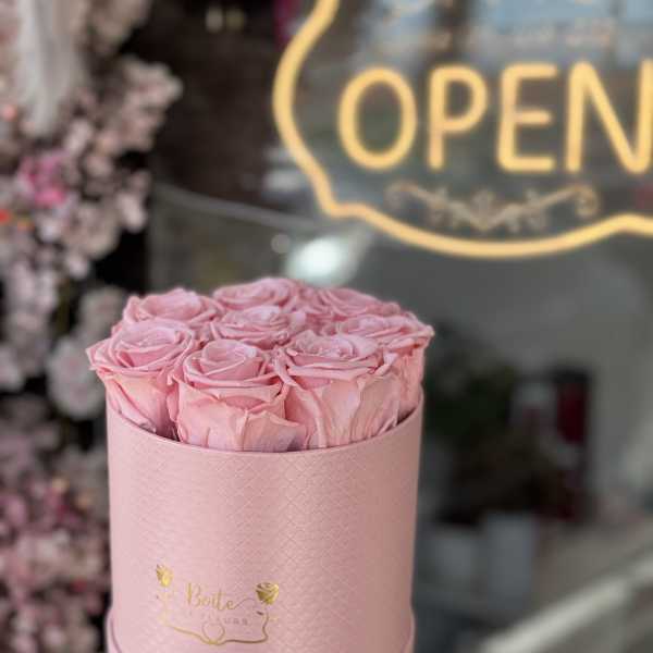 Pink roses arranged in a round pink box