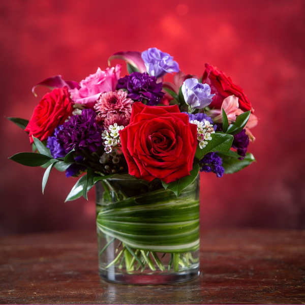 Red and purple mixed bouquet in a glass vase