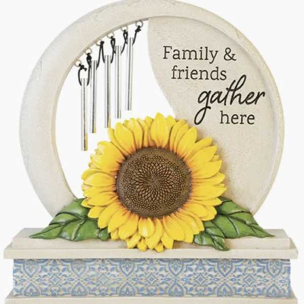 Decorative tabletop sign with a sunflower and hanging chimes