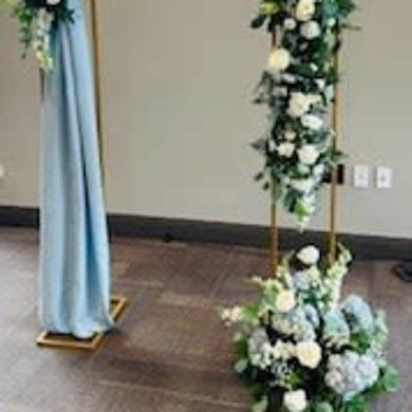 Floral arch with white flowers and blue draping fabric