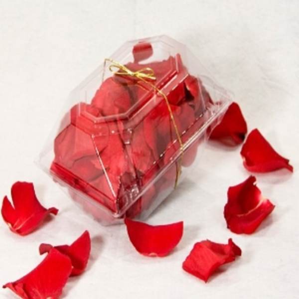 Clear gift box filled with red rose petals and tied with a gold ribbon