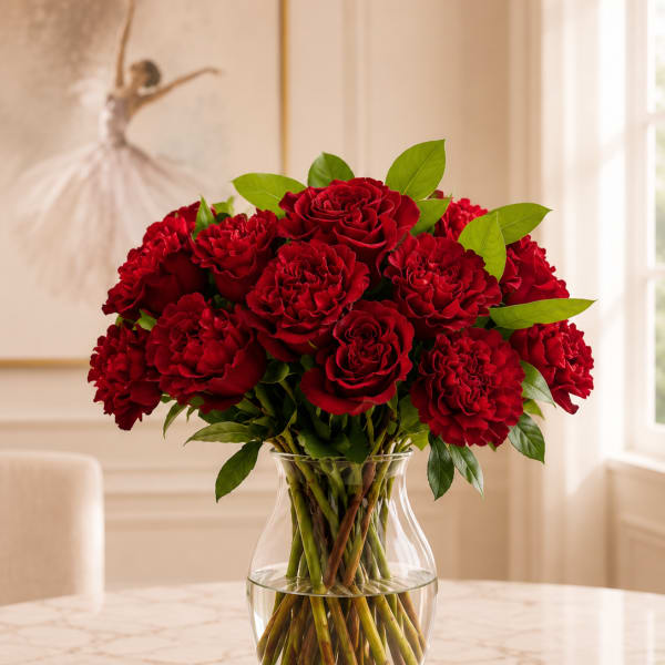 Red roses and carnations in a clear glass vase