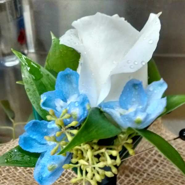 White calla lily with blue flowers in a small boutonniere