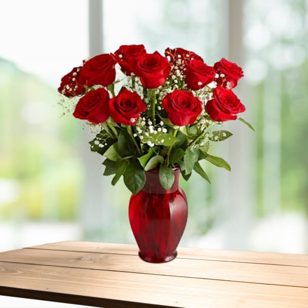Red roses arranged in a red glass vase