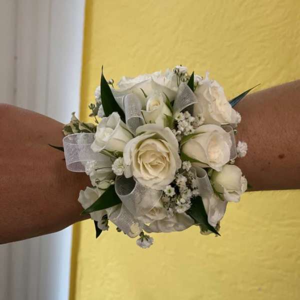 White rose wrist corsage with silver ribbon and green accents