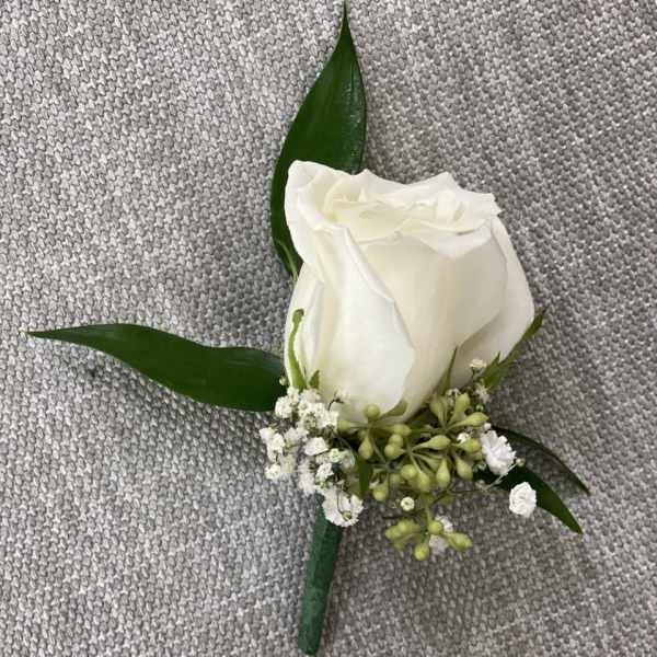 White rose boutonniere with small white filler flowers and green leaves