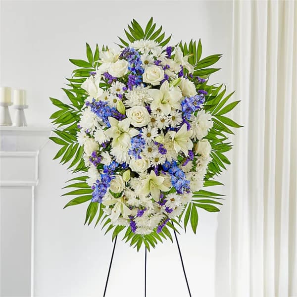 Standing floral spray of white and blue flowers on an easel