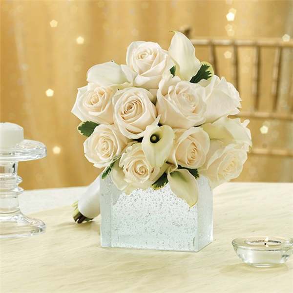 White rose bouquet in a glittery square vase with calla lilies