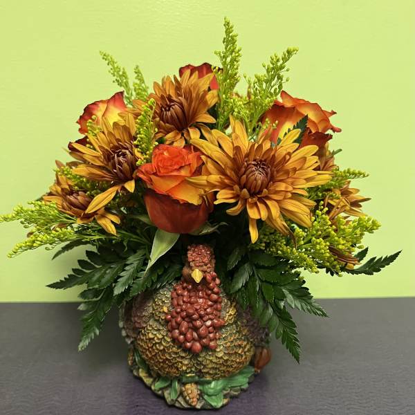 Autumn bouquet with orange roses and yellow chrysanthemums in a turkey vase