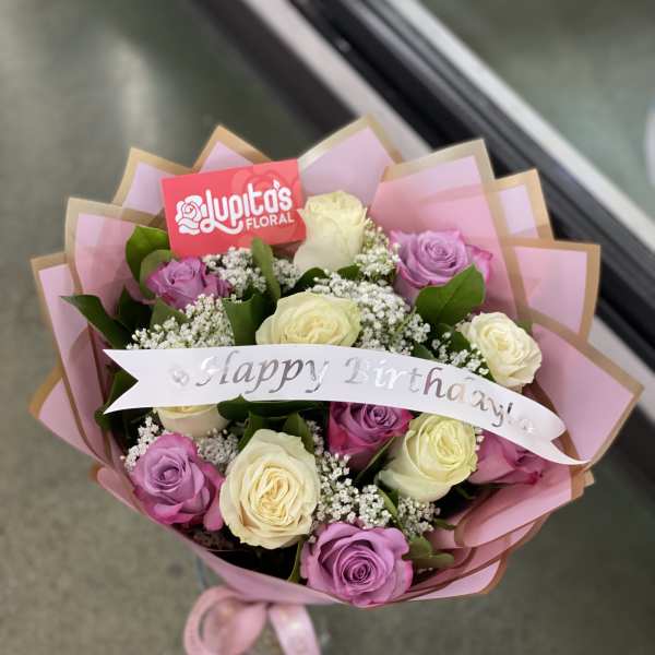 Bouquet of pink, lavender, and cream roses with a Happy Birthday ribbon