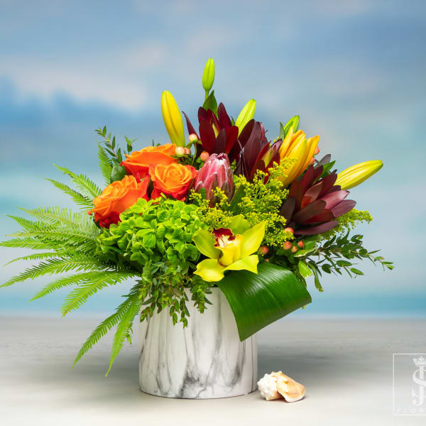 Bright mixed bouquet in a white marble vase with orange roses and yellow lilies
